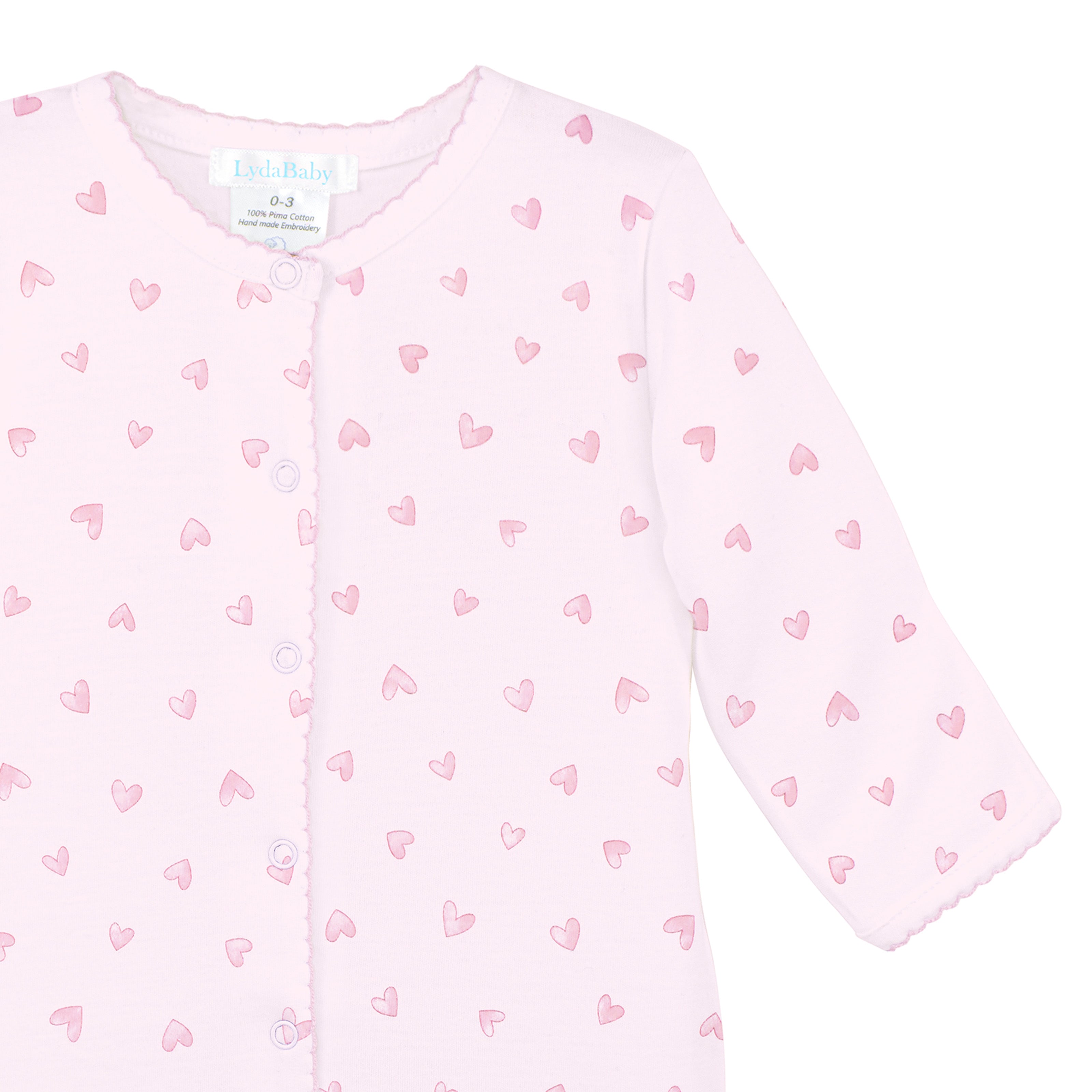 Pink newborn footie with soft watercolor heart print made from premium Peruvian Pima cotton.