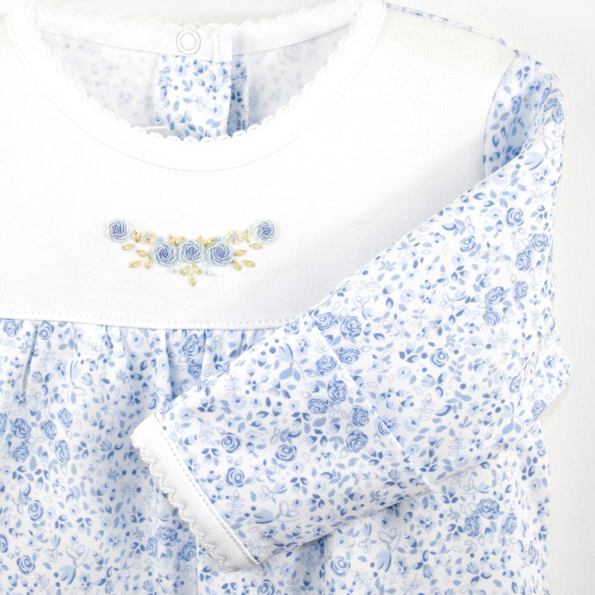 Luxury baby girl zipper sleeper crafted from Peruvian Pima cotton, featuring tiny blue roses printed all over and an embroidered rose detail on the chest — breathable, hypoallergenic, and timelessly charming.