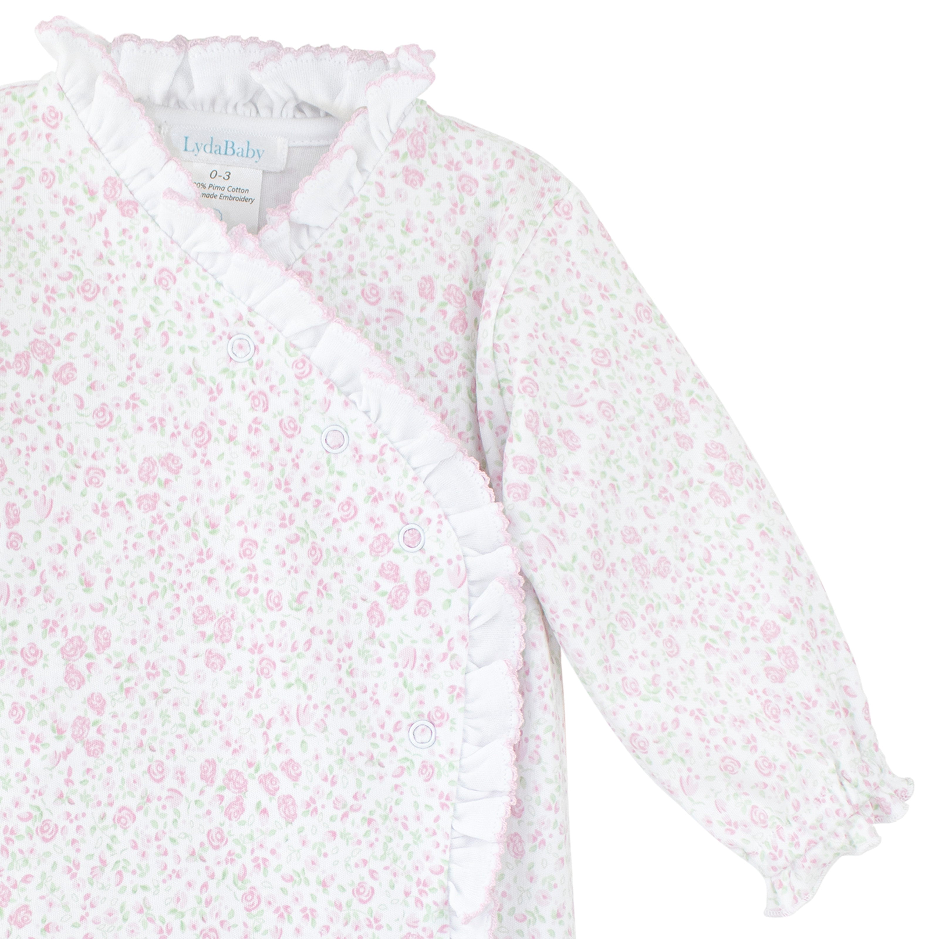Floral newborn onesie with crossed buttons and delicate ruffle trim made from soft Peruvian Pima cotton.