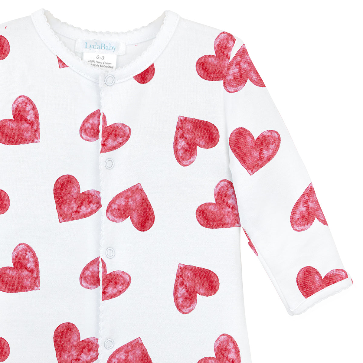 White baby footie with red watercolor heart print, medium-sized hearts all over.