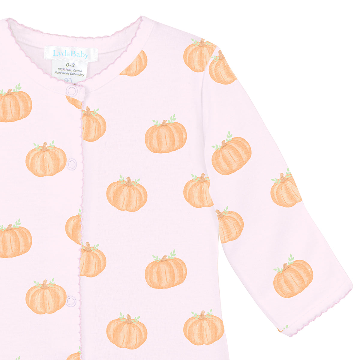 Luxury baby girl footie in soft pink Peruvian Pima cotton with playful orange pumpkin print, cozy and gentle for newborns.