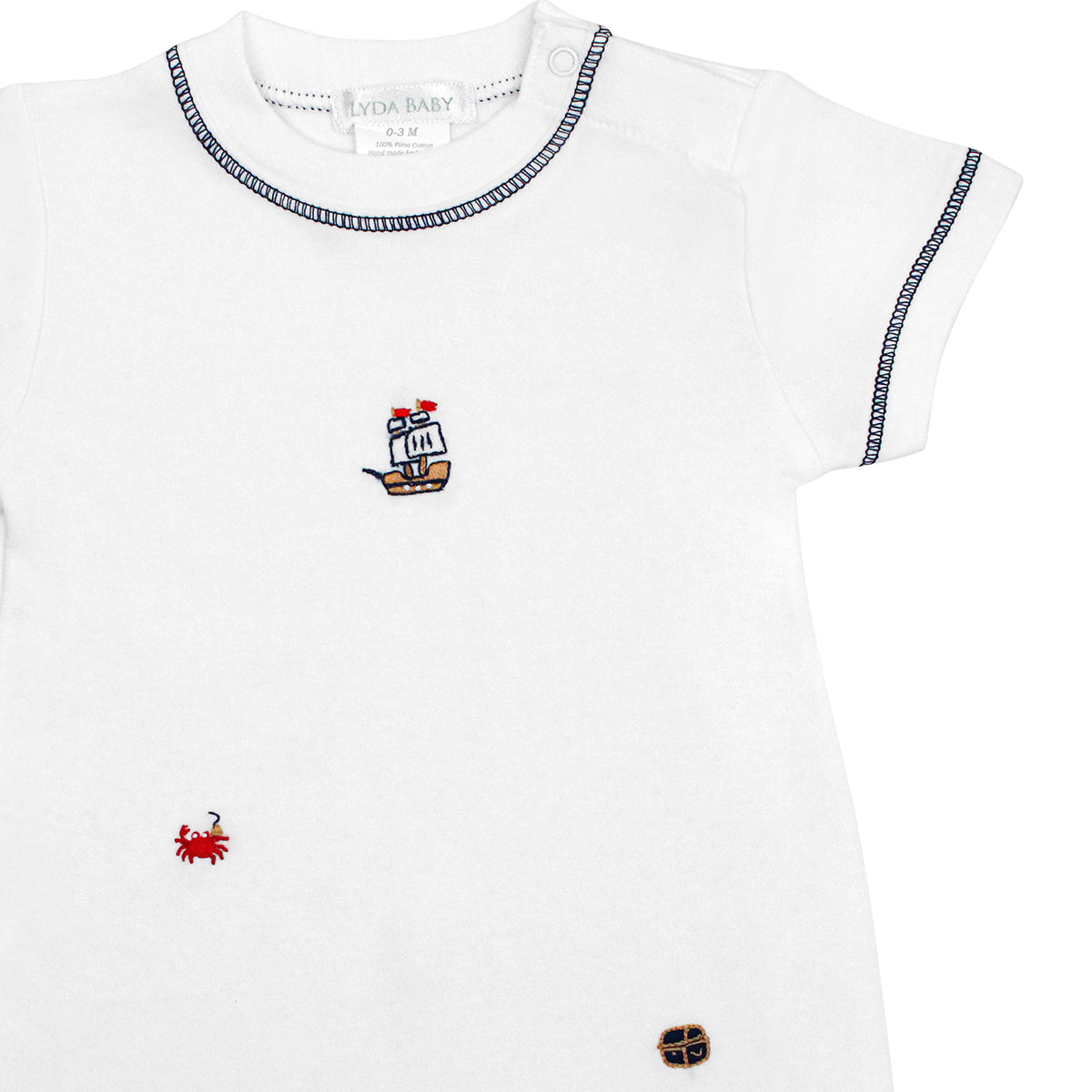 White baby boy romper with blue stitching, hand-embroidered pirate crab, ship, and treasure chest.
