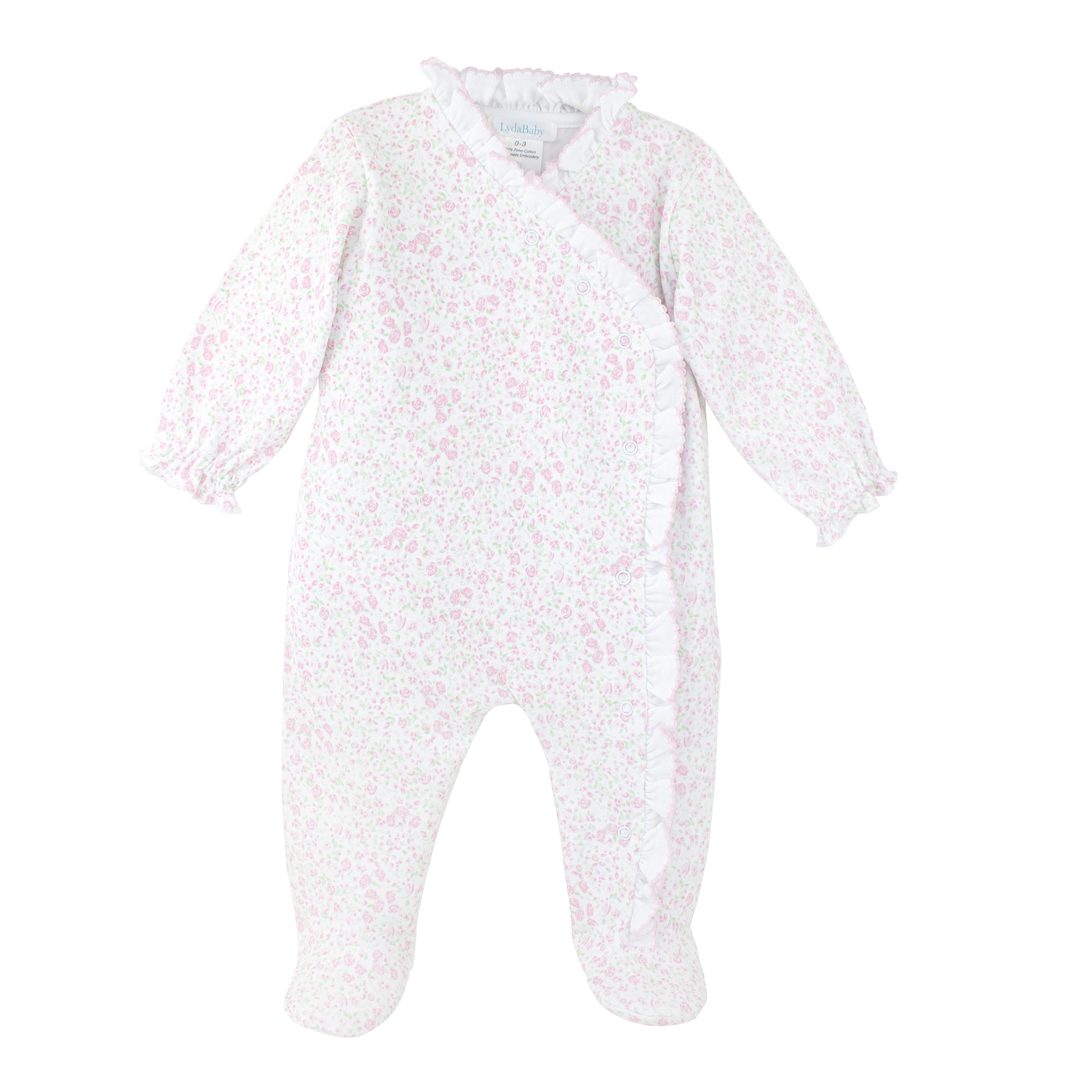 Luxury floral newborn onesie featuring crossed snap buttons and elegant ruffle trim crafted from premium Peruvian Pima cotton.